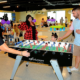 A woman and a kid playing foosball
